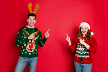Photo of crazy lady and guy directing fingers empty space on x-mas sale wear funky ugly ornament...