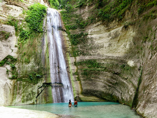 lovely travel couple alone at Tropical Waterfall in the jungle in Dao Falls in Cebu Island, Philippines