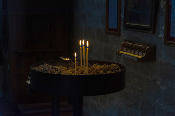 interior de una iglesia con la zona donde se ponen las velas para adoración de los santos