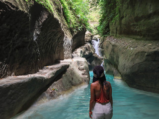 woman alone on the green canyon road at the middle of tropical jungle on the way of beautiful...