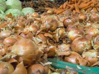 Baskets in a large market with various vegetables by weight. Onions, cabbage, carrots. Herbal ingredients for cooking.