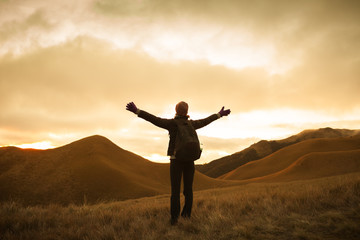 Female hiker up in the mountains feeling happy and free. 
