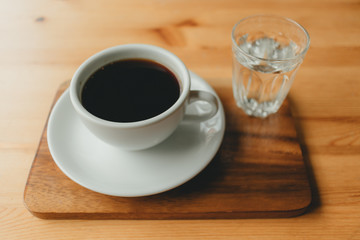 Hot cup of Americano coffee on wooden desk.