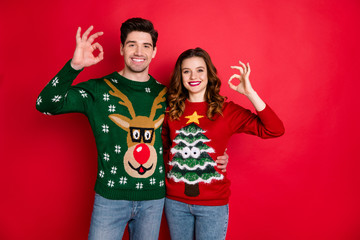 Portrait of cheerful two people student with brunette wavy hair hug embrace show ok sign sales wear...
