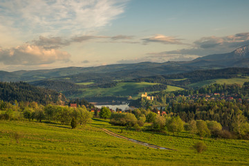 Obraz premium Panorama of snowy Tatra mountains and castle in Czorsztyn during spring sunset, Malopolskie, Poland
