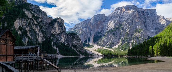 wooden house on the lake with mountains in the background