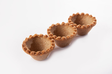 Three small rye pastry snack forms. View from above. Isolated object on a white background. Macro photo of tartlets.
