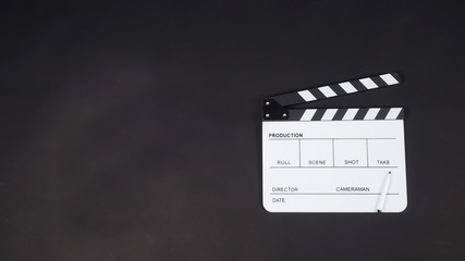 Black Clapperboard or clap board or movie slate with pen use in video production ,film, cinema industry.Put on black background.