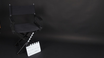 Fototapeta na wymiar Clapperboard or clap board or movie slate with director chair use in video production ,film, cinema industry on black background.