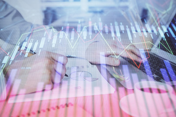 Multi exposure of stock market graph with man working on laptop on background. Concept of financial analysis.