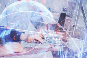 Multi exposure of chart with man typing on computer in office on background. Concept of hard work.