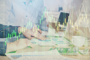 Multi exposure of chart with man typing on computer in office on background. Concept of hard work.