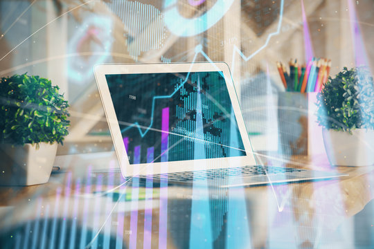 Financial graph colorful drawing and table with computer on background. Multi exposure. Concept of international markets.