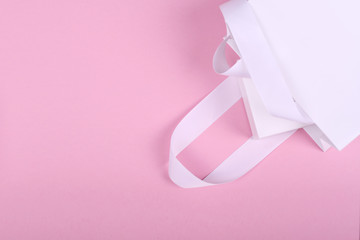 White gift box in white gift bag on pink background