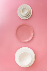 Top view of white and pink dish ware against colorful background.