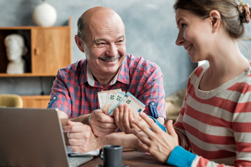 Olderly Spanish man gives his daughter money for a mortgage or student loan. Helping children while...