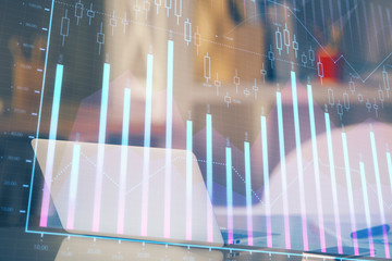 Stock market graph on background with desk and personal computer. Double exposure. Concept of financial analysis.