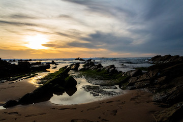 sunset at Barrika beach next to the rocks