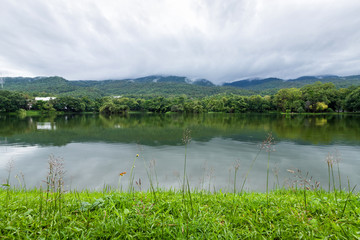 Fototapeta na wymiar green grass landscape lake views at Ang Kaew Chiang Mai University in nature forest Mountain views spring blue sky background with white cloud.