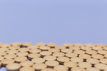 Many brown pills on a purple background