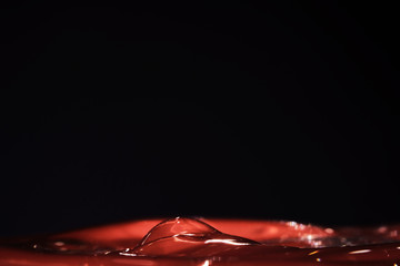 bright beautiful juicy red water with iridescent showy waves on a black background