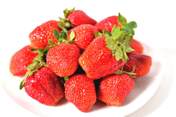 red big strawberries in a white plate on a white background with water drops on berries isolate