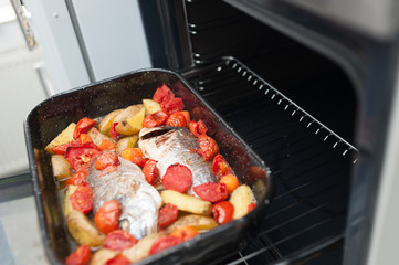 Fresh Baked fish with vegetables and potatoes in pan