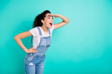 Fototapeta na wymiar Portrait of her she nice attractive lovely pretty cute cheerful cheery amazed girl wearing blue overall searching for friend isolated on bright vivid shine green turquoise background