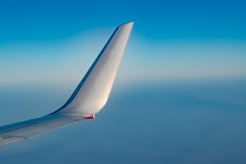 Winglet of Airplane from window, at high Altitude with crystal clear Blue Sky