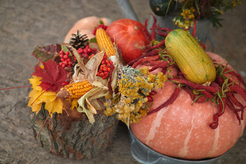 Autumn still life with pumpkins, berries, vegetables with leaves and decorative attributes in the...