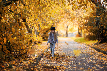 Fototapeta premium Girl walking in the autumn park. Autumn park