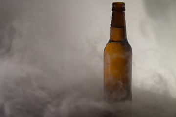 bottle and glass of beer on a fog  background