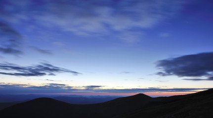 Fototapeta na wymiar Amazing sky before sunrise in the Carpathians, silhouettes of mountains on the horizon