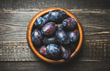Fresh ripe plums on the rustic background. Selective focus. Shallow depth of field.