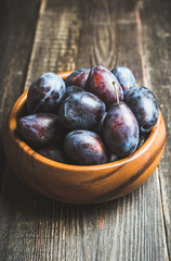 Fresh ripe plums on the rustic background. Selective focus. Shallow depth of field.