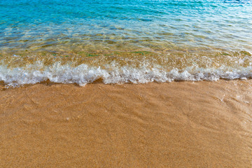 Small wave on golden sand with blue sea water, Corsica, France