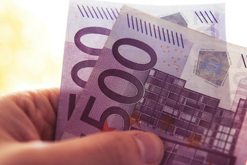 background with two 500 euro notes in a hand
