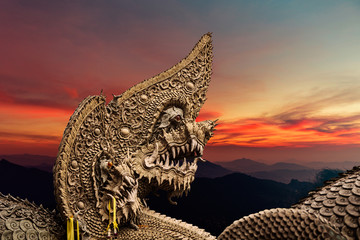 Serpent or naga statue head at sunset