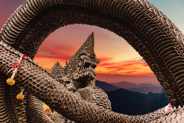 Serpent or naga statue head at sunset
