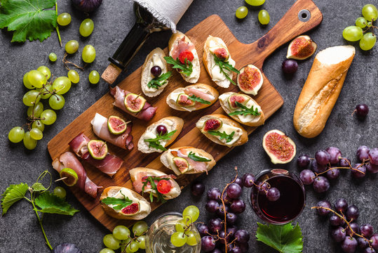 Traditional tapas bar, spanish table with food, platter with appetizers or italian bruschetta with cheese and meat. Wine snack set