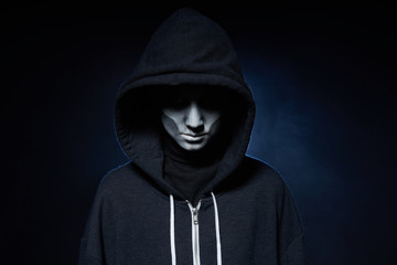 Boy with Halloween zombie makeup with hood on