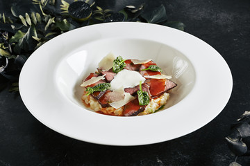 Exquisite Serving White Restaurant Plate of Risotto with Pecorino Cheese and Warm Roast Beef