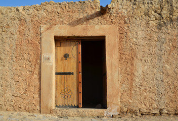 Small stone hut with a wooden door in the dessert oasis of Chebika
