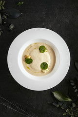 Exquisite Serving White Restaurant Plate of Cream Cappuccino Soup with Porcini Mushrooms and Truffle Top View