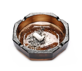 Cigarette in glass ashtray isolated on white background
