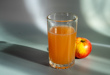 Apple and freshly squeezed apple juice in a glass.