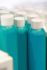 Row of blue blank bottles with cosmetic products in shop. creams and other products for skin care of face and body