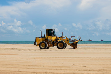 Tractor is working on the beach.