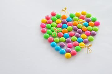 Place colorful candies into concept of heart symbol. Love and colorful concept.