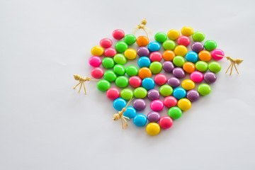 Place colorful candies into concept of heart symbol. Love and colorful concept.